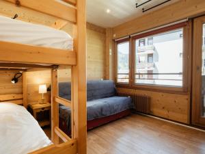 a bunk bed and a couch in a room at Appartement La Clusaz, 3 pièces, 6 personnes - FR-1-304-77 in La Clusaz