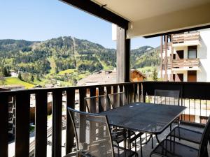 a table and chairs on a balcony with a view at Appartement La Clusaz, 3 pièces, 6 personnes - FR-1-304-77 in La Clusaz