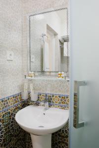 uma casa de banho com um lavatório branco e um espelho. em Ko'k Saroy Plaza Hotel em Samarkand