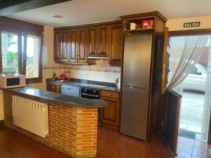 eine Küche mit einem Kühlschrank und einer Ziegelwand in der Unterkunft Apartamentos La Portilla in El Tejo
