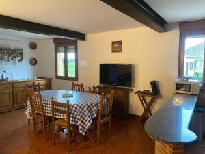 eine Küche mit einem Tisch mit Stühlen und einem TV in der Unterkunft Apartamentos La Portilla in El Tejo