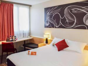 um quarto de hotel com uma cama e uma secretária em ibis Tours Nord em Tours