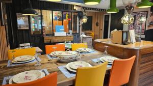- une table avec des chaises et des assiettes dans un restaurant dans l'établissement Au P'tit Quinquin, à Céaux