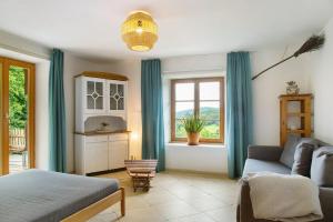 ein Wohnzimmer mit einem Bett und einem Sofa in der Unterkunft Landhaus am Eselhof Daxstein in Schöllnach