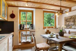eine Küche mit einem Tisch und Stühlen im Zimmer in der Unterkunft Landhaus am Eselhof Daxstein in Schöllnach