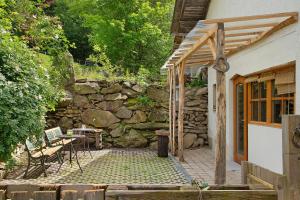 un patio con una pared de piedra junto a un edificio en Landhaus am Eselhof Daxstein en Schöllnach