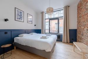 a bedroom with a large bed and a brick wall at Petite Dinant - Feet in water hands on the rock in Dinant
