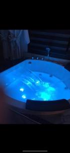 - une grande baignoire bleue avec lavabo dans l'établissement L'Aurore suite de charme, clim jacuzzi, sauna, piscine chauffée cuisine..., à Carpentras