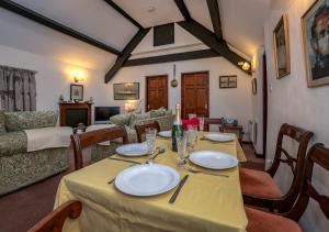 uma sala de jantar com uma mesa e uma sala de estar em The Cottage em Llanbedrog