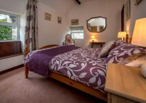 um quarto com uma cama grande e um espelho em The Cottage em Llanbedrog