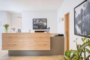an office with a wooden reception desk with a potted plant at Best Western Hotel Lippstadt in Lippstadt