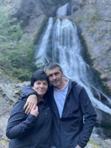 a man and woman standing in front of a waterfall at Adina Vendégház in Sîncraiu