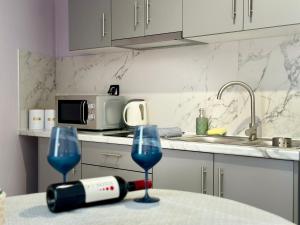 a kitchen with two glasses of wine on a table at Anemos Studios & Apartments in Póros Kefalonias