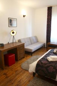 a bedroom with a bed and a couch and a table at Casa Romana in Turda