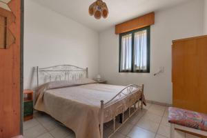 a bedroom with a bed and a window at Casa di Tosca by BarbarHouse in Torre dell'Orso