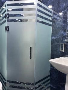 uma cabina de duche em vidro na casa de banho com um lavatório em Ko'k Saroy Plaza Hotel em Samarkand
