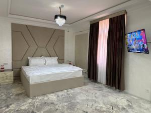 撒馬爾罕的住宿－Ko'k Saroy Plaza Hotel，一间卧室设有一张大床和一个窗户。