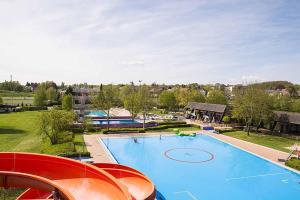 a large swimming pool with red chairs next to it at Ferienwohnung Altstadtherz in Tirschenreuth
