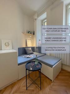 um pequeno quarto com uma cama e uma mesa em Urban Retreat I Modern Boho Apartments in Lovely Letná District - 10 minutes from Old Town em Praga