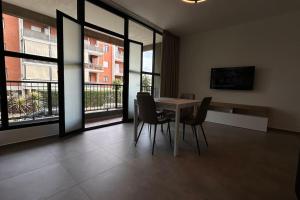 ein Esszimmer mit Tisch und Stühlen und Fenstern in der Unterkunft CconfortHotels Puglia Promenade Apartment 2 in Bari + 6 Fotos