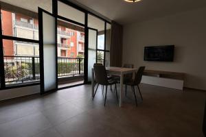 ein Esszimmer mit Tisch und Stühlen und Fenstern in der Unterkunft CconfortHotels Puglia Promenade Apartment 2 in Bari