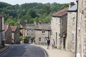 two people walking down a street in a village at Nook Cottage in Richmond