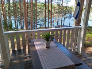 a table on a porch with a plant on it at Kalliomökki in Puumala