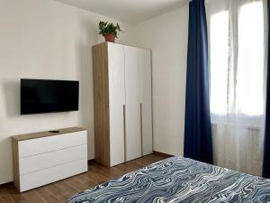 a bedroom with a bed and a cabinet with a tv at Casa Curcio in Bologna