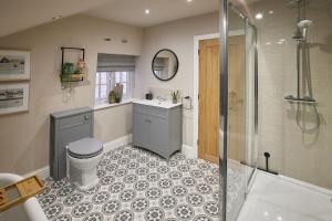 a bathroom with a shower and a toilet and a sink at Nook Cottage in Richmond +19 photos