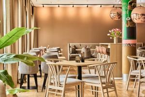 un restaurante con mesas, sillas y plantas en Smarthotel Forus en Stavanger