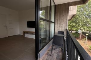 a glass balcony with a table and a chair at CconfortHotels Puglia Promenade Apartment 3 in Bari