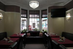 a dining room with tables and a couch and windows at Cardoh Lodge in Blackpool