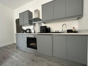 a kitchen with white cabinets and an oven at Luxury studio flat in London