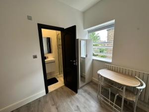 a small room with a table and a window at Luxury studio flat in London