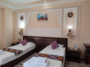 ein Hotelzimmer mit 2 Betten und 2 Tischen in der Unterkunft Hotel Shams in Buxoro