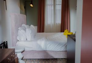 una camera d'albergo con un letto bianco e una sedia di Bugan-Villa ad Atene