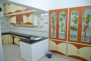 a kitchen with wooden cabinets with flowers on them at Nanda Mohan Homestay- Luxury AC Apartment close to Alipiri Kapila Teertha and ISKON temples in Tirupati