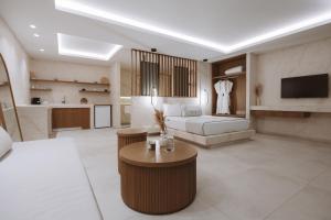 a bedroom with a bed and a living room at Pnoe Luxury Suites in Fira