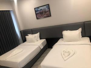 2 Betten in einem Hotelzimmer mit Herz drauf in der Unterkunft Urbanite Hotel in Vientiane