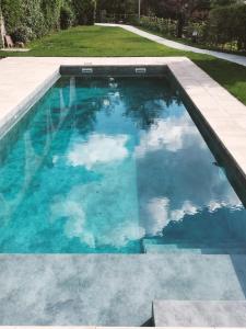 a swimming pool with blue water and clouds at Les Planes de Viladrau in Viladrau
