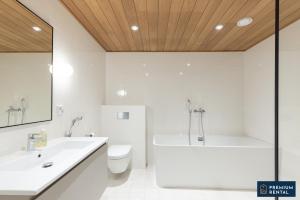 a bathroom with a tub and a toilet and a sink at A13 Premium Double room II floor in Hanko