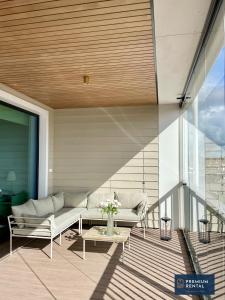 a patio with a couch and a table on a balcony at A13 Premium Double room II floor in Hanko