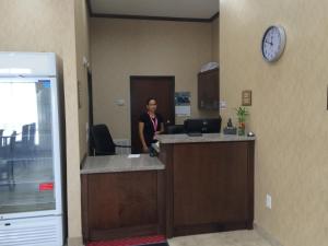 a woman standing at a counter in an office at La Bonita Inn & Suites - Crane in Crane