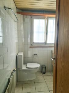 La salle de bains est pourvue de toilettes et d'une fenêtre. dans l'établissement Abendberg - zentral nähe Bahnhof, à Wilderswil
