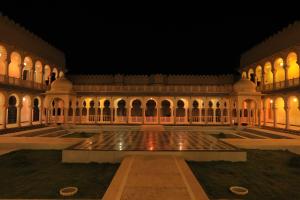a courtyard of a building with a fountain at night at Kesarbagh Palace in Chittaurgarh