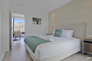 Un dormitorio con una gran cama blanca y un balcón. en ViVi Homes - Levalin Wellness, Pool & Terrace, en Fuengirola 38 fotos más