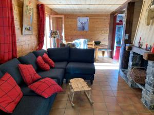 a living room with a blue couch and red pillows at Les Chalets-Hôtel de la Croix-Fry in Manigod