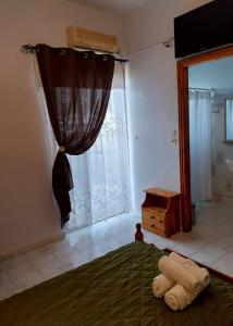 a bedroom with a bed and a window with a curtain at Meltemi Rooms and Apartments in Finikounta +88 photos