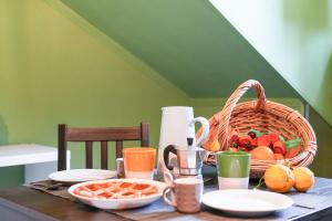 una mesa con una cesta de fruta y una cesta de pan en Smeralda Attic Room, en Turín