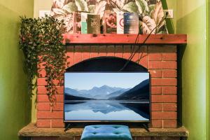 einen TV in einem gemauerten Kamin mit Blick auf das Wasser in der Unterkunft Smeralda Attic Room in Turin